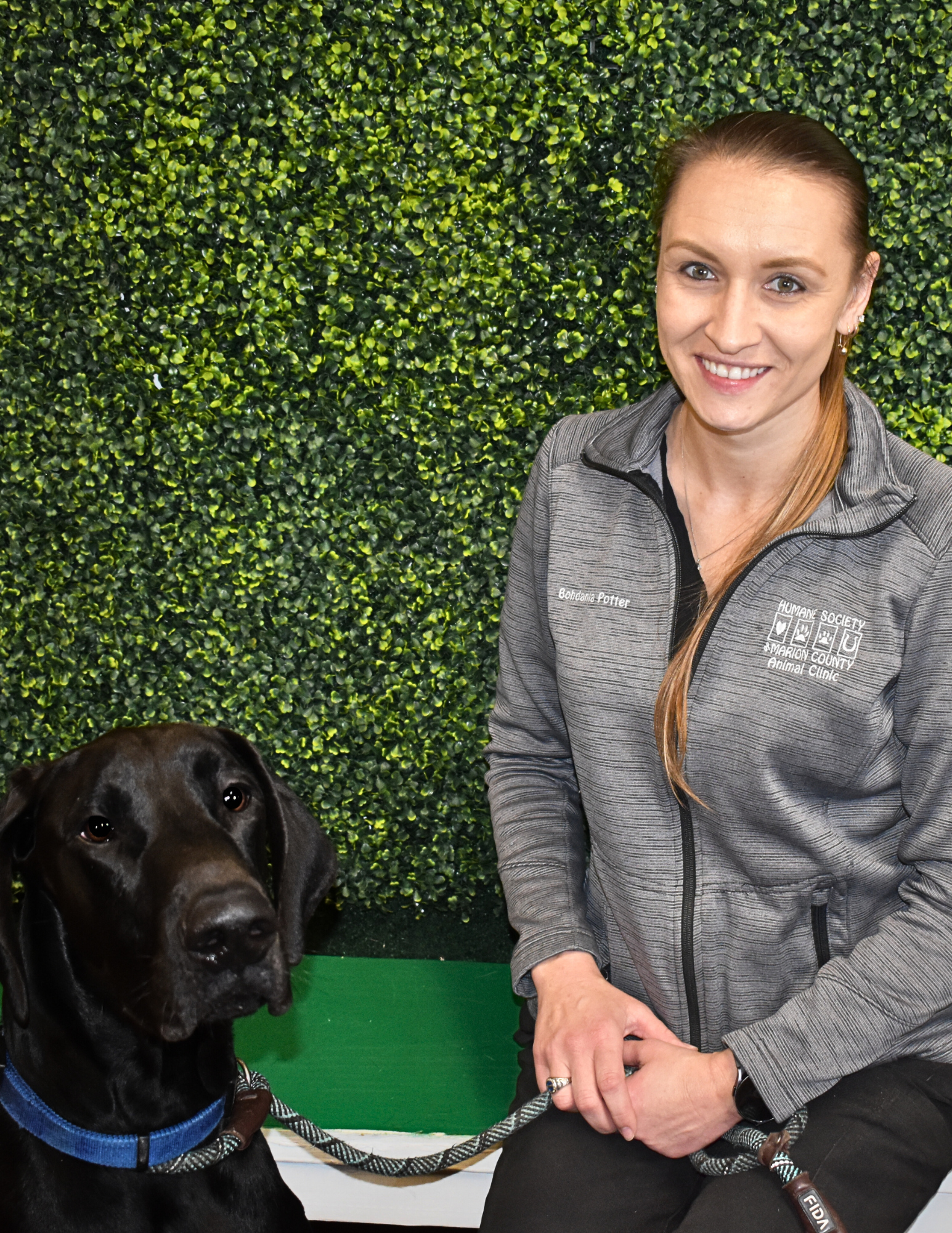 Bohdania Potter, Shelter Lead Vet Tech, with a black dog.